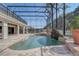 Enclosed pool area with rock waterfall feature, lush plants and tiled surround for relaxation at 10231 Lenox St, Clermont, FL 34711