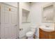 A functional powder room featuring a classic white toilet, wooden accents, and framed mirror at 10231 Lenox St, Clermont, FL 34711