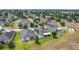 An aerial view of a residential neighborhood featuring sidewalks, mature trees, and houses with solar panels at 1061 Suffragatte Cir, Haines City, FL 33844