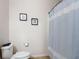 This bathroom has a toilet, towel rack, and shower with a blue striped curtain at 1061 Suffragatte Cir, Haines City, FL 33844