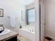 Bright bathroom featuring a soaking tub, a window for natural light, and modern fixtures at 1061 Suffragatte Cir, Haines City, FL 33844