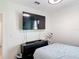 Modern bedroom with a mounted TV, dark furniture, and a window for natural light at 1061 Suffragatte Cir, Haines City, FL 33844