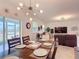 Dining room features a wooden table set for six, modern light fixture, and seamless access to living area at 1061 Suffragatte Cir, Haines City, FL 33844