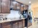 Contemporary kitchen with dark wood cabinets, granite countertops, and stainless steel appliances at 1061 Suffragatte Cir, Haines City, FL 33844