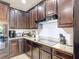 This spacious kitchen features dark wood cabinetry, granite countertops, and modern stainless steel appliances at 1061 Suffragatte Cir, Haines City, FL 33844