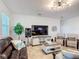 Bright and airy living room featuring comfortable seating, a large TV, and tasteful decor at 1061 Suffragatte Cir, Haines City, FL 33844
