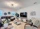 Relaxing living room with leather couches and patterned chairs illuminated by a modern chandelier at 1061 Suffragatte Cir, Haines City, FL 33844