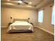 A bright primary bedroom features a ceiling fan, two windows and hard surface flooring at 1062 Rock Creek St, Apopka, FL 32712