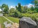 Backyard featuring a well-maintained lawn, brick patio, black metal fence and a Weber grill at 1086 Calla Lily Cv, Oviedo, FL 32766