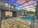 Backyard view showcasing the screened pool, outdoor seating, and lush landscaping at sunset at 1086 Calla Lily Cv, Oviedo, FL 32766