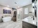 Modern bathroom featuring a soaking tub, tiled shower, double vanity, and stylish decor at 1086 Calla Lily Cv, Oviedo, FL 32766