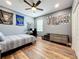 A sporty bedroom with hardwood floors, ceiling fan and a gray accent wall with trophies and pennants at 1086 Calla Lily Cv, Oviedo, FL 32766