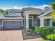 Charming two-story home with a brick driveway, beautiful landscaping, and a welcoming front porch at 1086 Calla Lily Cv, Oviedo, FL 32766