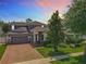 Two-story home with a brick driveway, a grey exterior, mature trees and a neatly landscaped front yard at 1086 Calla Lily Cv, Oviedo, FL 32766