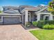 Charming two-story home with a brick driveway, beautiful landscaping, and a welcoming front porch at 1086 Calla Lily Cv, Oviedo, FL 32766