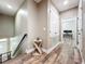 Hallway with hardwood floors leading to an office space with multiple monitors at 1086 Calla Lily Cv, Oviedo, FL 32766