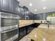 Modern kitchen showcases dark cabinets, granite countertops, and stainless steel oven appliance at 1086 Calla Lily Cv, Oviedo, FL 32766