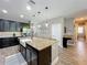 Open kitchen with dark cabinetry, granite island with seating, and stainless steel appliances at 1086 Calla Lily Cv, Oviedo, FL 32766
