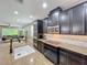 Kitchen featuring dark cabinets, granite counters, subway tile backsplash, and stainless steel appliances at 1086 Calla Lily Cv, Oviedo, FL 32766
