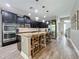 Well-equipped kitchen with dark cabinetry, granite island with seating, and stainless steel appliances at 1086 Calla Lily Cv, Oviedo, FL 32766