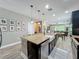 Bright kitchen boasts granite island with seating, stainless steel appliances, and open layout to living area at 1086 Calla Lily Cv, Oviedo, FL 32766