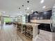 Spacious kitchen features dark cabinetry, granite countertops, island with seating, and wood-look tile flooring at 1086 Calla Lily Cv, Oviedo, FL 32766