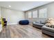 Spacious living room with a cozy gray sofa, a Pac-Personal arcade game, and hardwood floors at 1086 Calla Lily Cv, Oviedo, FL 32766