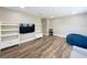 Open concept living room with shelving, flatscreen TV, and hardwood floors at 1086 Calla Lily Cv, Oviedo, FL 32766