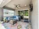 Inviting covered patio with comfortable seating, ceiling fan, and mounted TV for outdoor relaxation at 1086 Calla Lily Cv, Oviedo, FL 32766