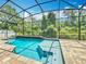 Inviting pool with screened enclosure, waterfall feature and a spacious deck for ultimate relaxation at 1086 Calla Lily Cv, Oviedo, FL 32766