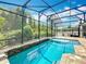 Tranquil pool area with a screened enclosure, stone accents, and lush greenery, offering a private retreat at 1086 Calla Lily Cv, Oviedo, FL 32766