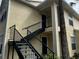 View of the side of the condo building with dark metal stairs at 1089 S Hiawassee Rd # 323, Orlando, FL 32835