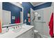 Stylish bathroom featuring a white vanity, a glass-enclosed shower, and bold blue walls at 1184 Fern Ave, Orlando, FL 32814