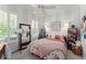 Cozy bedroom with a floral patterned bed, a full length mirror and natural light from large windows at 1184 Fern Ave, Orlando, FL 32814