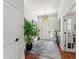 Bright foyer with wood floors, a chandelier, and a large potted plant, creating an inviting entrance to the home at 1184 Fern Ave, Orlando, FL 32814