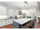 Modern kitchen with white cabinets, a center island with seating, and open access to the dining area at 1184 Fern Ave, Orlando, FL 32814
