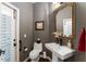 Elegant powder room featuring patterned walls, decorative mirror, sink and toilet at 1184 Fern Ave, Orlando, FL 32814