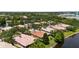 An aerial view of residences, featuring well-maintained landscaping, tile roofs, and peaceful waterfront scenery at 11863 Delfina Ln, Orlando, FL 32827