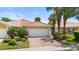 Beautiful single-story home featuring a red tile roof, lush landscaping, and a brick-paved driveway at 11863 Delfina Ln, Orlando, FL 32827