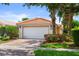 Charming single-story home featuring a red tile roof, lush landscaping, and a brick-paved driveway at 11863 Delfina Ln, Orlando, FL 32827