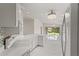 Open concept kitchen showcasing modern appliances and counter space, flowing into a living area with a hammock view at 11863 Delfina Ln, Orlando, FL 32827