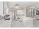 Kitchen featuring white countertops, appliances, and mosaic backsplash adjacent to an open-concept living area at 11863 Delfina Ln, Orlando, FL 32827