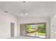 Living room boasting modern pendant lighting and large sliding glass doors with a view of the backyard hammock at 11863 Delfina Ln, Orlando, FL 32827