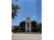 Elegant town center building featuring a clock tower, surrounded by palm trees and manicured landscaping at 11863 Delfina Ln, Orlando, FL 32827