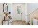 Bright entryway featuring wood flooring, a stylish mirror, and a clear view of the front door at 11944 Sunsail Ave, Orlando, FL 32832