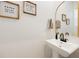 Clean half bathroom features a modern sink and funny framed pictures at 11944 Sunsail Ave, Orlando, FL 32832