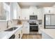 Well-lit kitchen with white cabinets, stainless steel appliances, and stylish backsplash at 11944 Sunsail Ave, Orlando, FL 32832