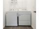 Functional laundry area with modern washer and dryer units and overhead shelving at 11944 Sunsail Ave, Orlando, FL 32832