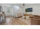 Bright living room with wood floors, neutral furnishings, and large-screen TV at 11944 Sunsail Ave, Orlando, FL 32832