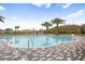 Resort-style pool with a zero entry point, bordered by lounge chairs, palm trees, and tropical landscaping at 11944 Sunsail Ave, Orlando, FL 32832